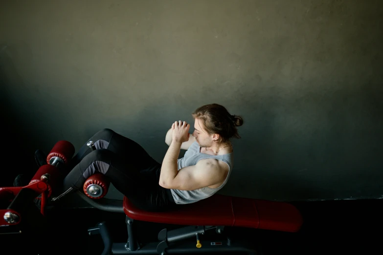 a man sitting on top of a red bench, local gym, lachlan bailey, woman is curved, profile image