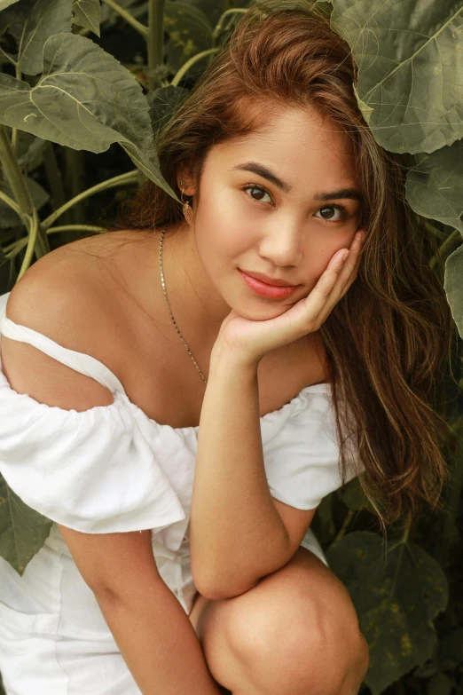 a woman in a white dress posing for a picture, by Robbie Trevino, trending on pexels, lush foliage, 18 years old, actress, close up shot from the top