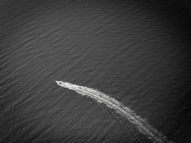 a black and white photo of a boat in the water, minimalism, drone footage, high speed, video footage, portlet photo