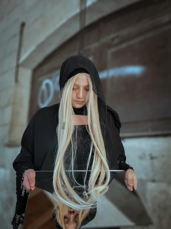 a woman with long blonde hair standing in front of a mirror, an album cover, inspired by INO, unsplash, renaissance, wearing a black hoodie, cosplay photo, cable wires as hair, washing her dark long hair