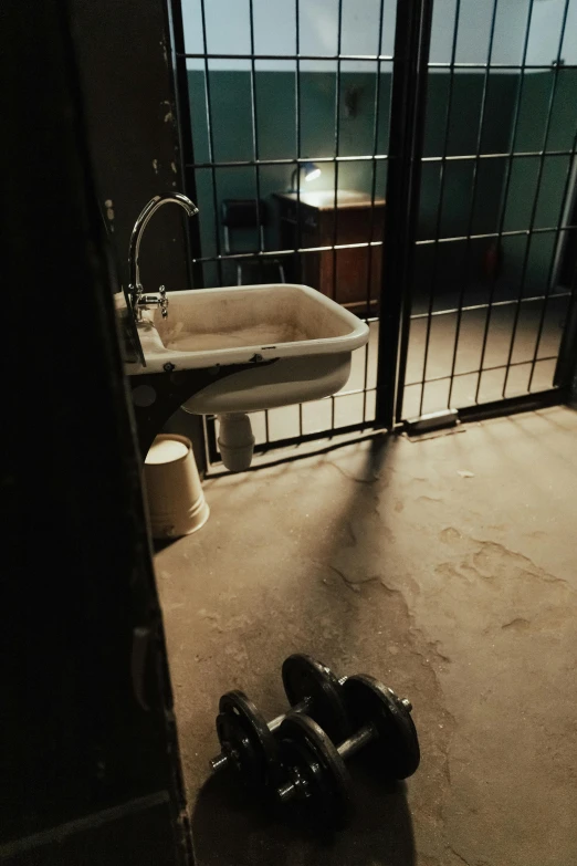 a bathroom with a sink and a mirror, inspired by Elsa Bleda, unsplash, conceptual art, prison scene, ground level view, brown, nighttime