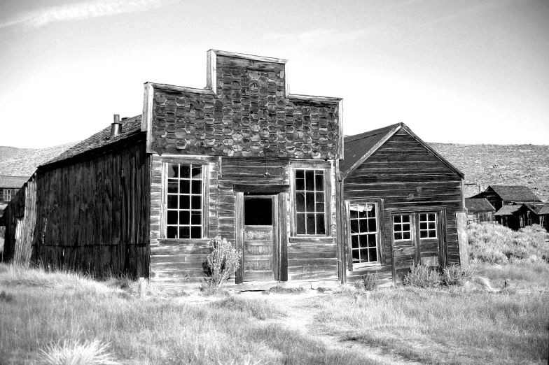 a black and white photo of an old building, by Lynn Pauley, pexels contest winner, in a wild west town, background image, empty buildings, full front view