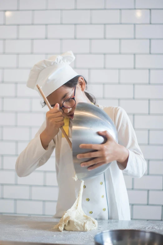 a woman in a chef's hat mixing food in a mixing bowl, inspired by François Bocion, pexels contest winner, girl wearing round glasses, holding a balloon, holding helmet, white uniform