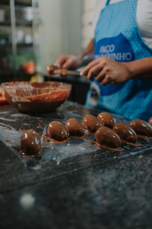 a woman preparing chocolate covered donuts in a kitchen, by Jacob Pynas, pexels contest winner, rio de janeiro, translucent eggs, panoramic shot, boys