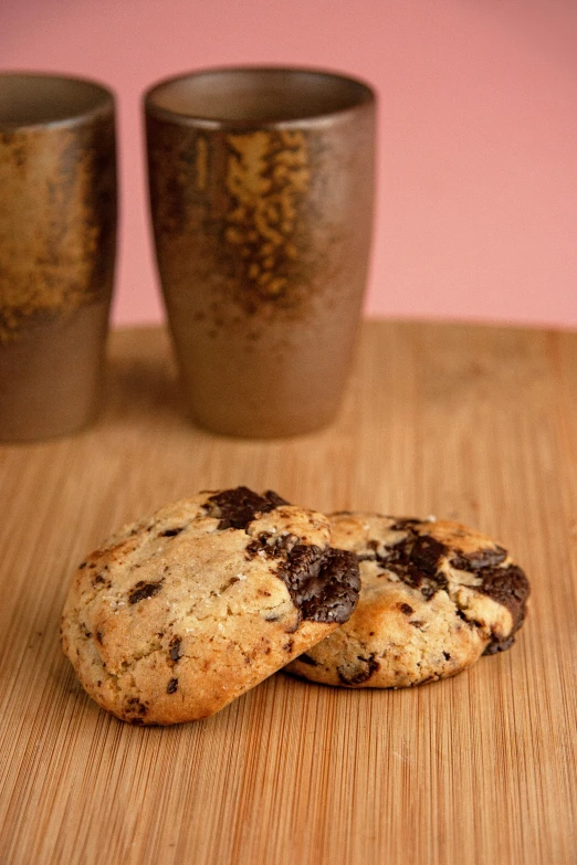 a couple of cookies sitting on top of a wooden table, bombshell, full product shot, full frontal shot, granite