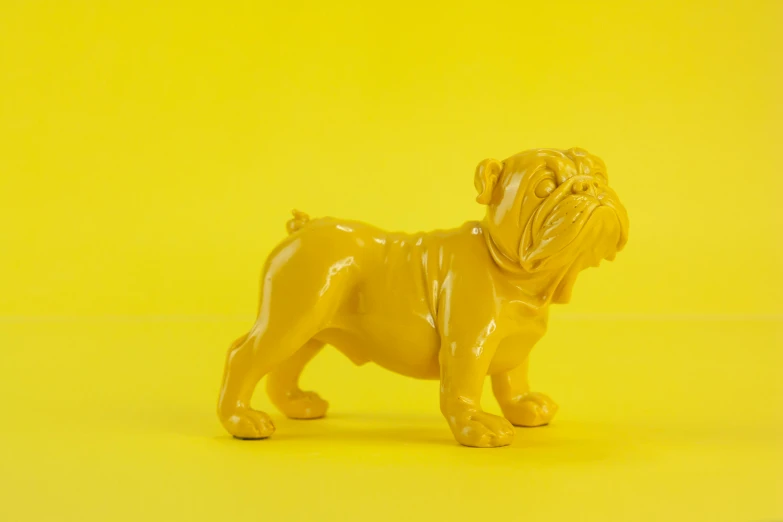 a yellow figurine of a dog on a yellow background, inspired by Fernando Botero, unsplash, new sculpture, gold striated swirling finish, high quality product photo, feng zhu |, vintage