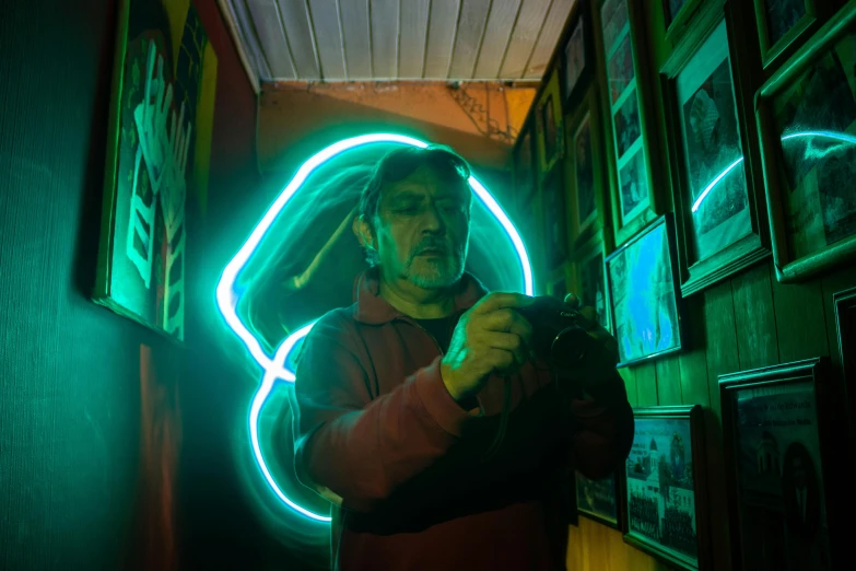 a man standing in a hallway holding a camera, a hologram, by Alejandro Obregón, pexels contest winner, interactive art, some have neon signs, an oldman, he is casting a lighting spell, art foreground : eloy morales
