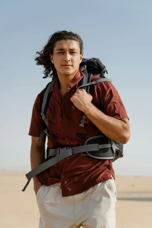 a man with a backpack standing in the desert, with long dark hair, robert sheehan, egypt, slide show