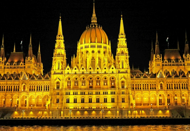 a large building that is lit up at night, by Thomas Häfner, shutterstock, renaissance, budapest, golden towers, insanly detailed, parliament