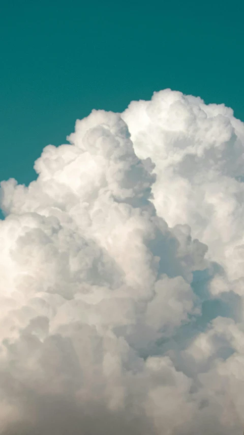 a jetliner flying through a cloud filled sky, by James Morris, unsplash, romanticism, giant cumulonimbus cloud, profile image, teal sky, cotton candy