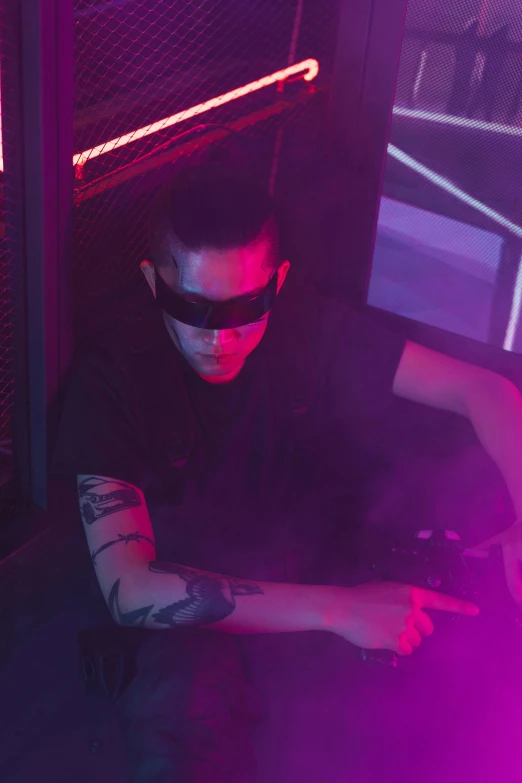 a man sitting on the ground using a cell phone, cyberpunk art, trending on reddit, holography, in a nightclub, wearing shiny black goggles, in front of a computer, bad bunny