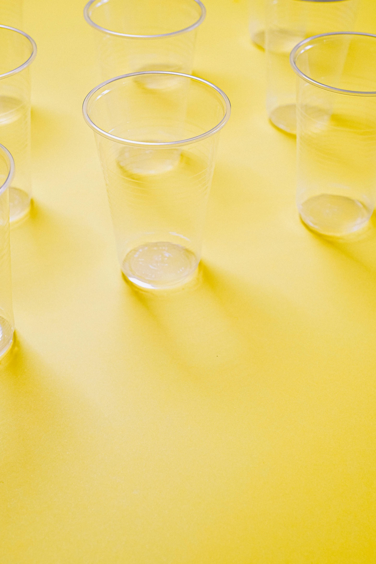 a group of plastic cups sitting on top of a yellow table, detailed product image, crisp and clear, carefully crafted, no - text no - logo