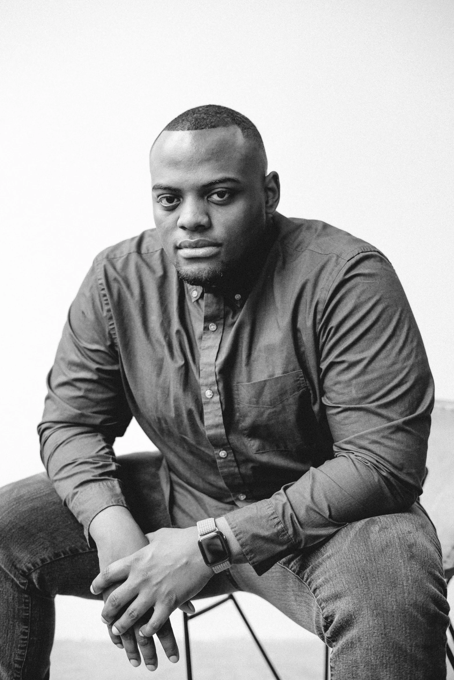 a black and white photo of a man sitting on a chair, pexels contest winner, black arts movement, in a dark teal polo shirt, antoine-jean gr, kehinde wiley, promotional image