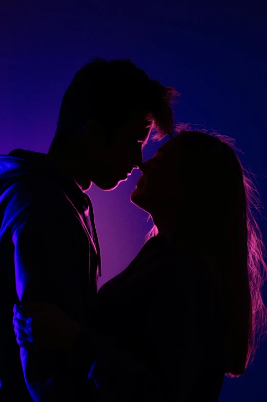 a man and a woman standing next to each other, by Matt Cavotta, pexels contest winner, romanticism, blue and purple lighting, teenage girl, making out, profile pic