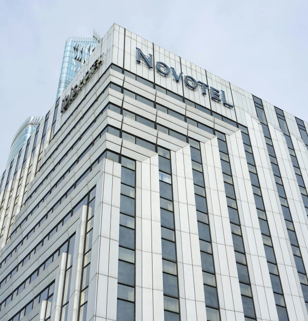 a tall building with a sign on top of it, by Nōami, pexels contest winner, art nouveau, nova, hotel room, square, minneapolis