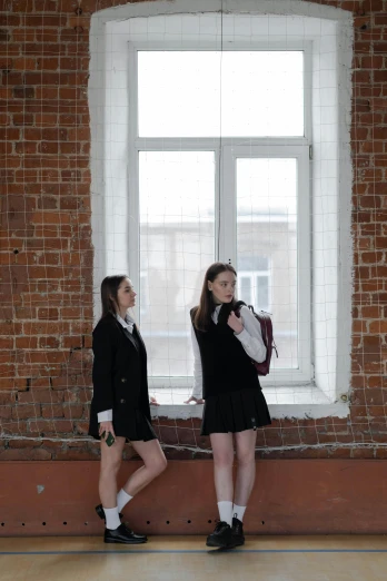 two girls standing next to each other in front of a window, trending on pexels, antipodeans, school girl in gothic dress, alexey gurylev, on a wall, ( ( theatrical ) )