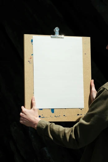 a man holding a piece of paper in his hands, inspired by James Ryman, featured on reddit, visual art, easel, extremely high resolution, close - up photograph, ilustration