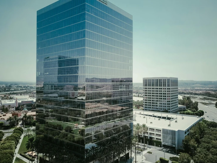 a large glass building in the middle of a city, unsplash, 1600 south azusa avenue, two towers, drone photograpghy, full daylight