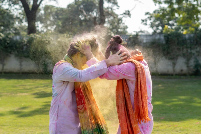 a couple of women standing on top of a lush green field, pexels contest winner, holi festival of rich color, covered in white flour, beautiful man, college