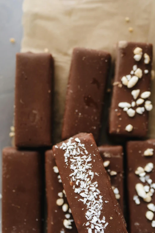 a pile of chocolate bars sitting on top of a table, luscious with sesame seeds, thumbnail, chalk, chiffon