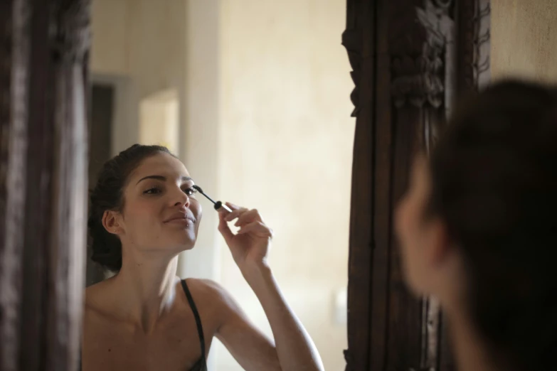 a woman brushes her teeth in front of a mirror, by Arabella Rankin, pexels contest winner, renaissance, black eye makeup, phoebe tonkin, wearing eye shadow, thumbnail