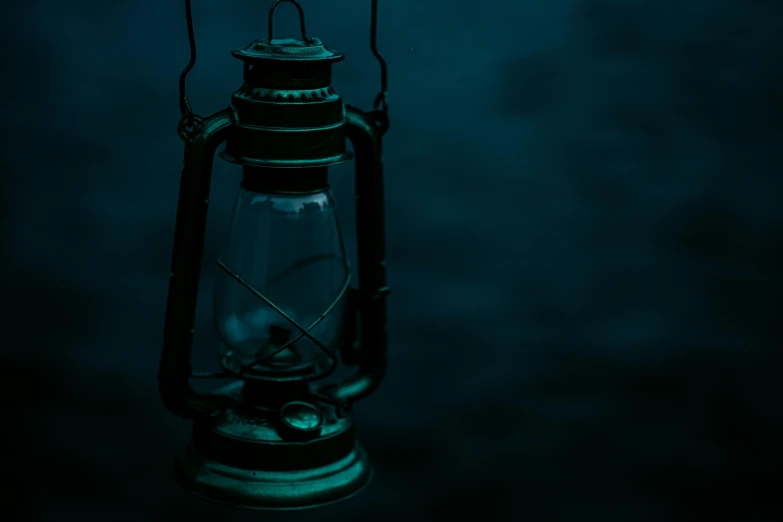 a lantern is lit up in the dark, an album cover, pexels contest winner, realism, desaturated blue, background image, scary mood, teal lighting