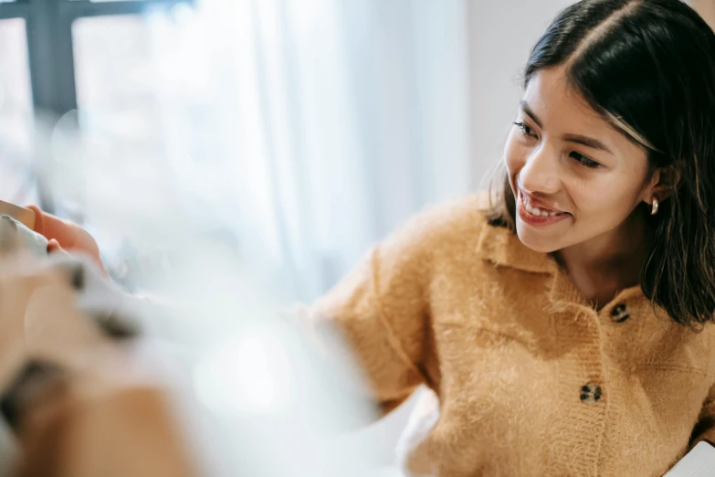 a little girl sitting at a table with a plate of food, trending on pexels, academic art, smiling young woman, looking into a mirror, blurred detail, healthcare worker