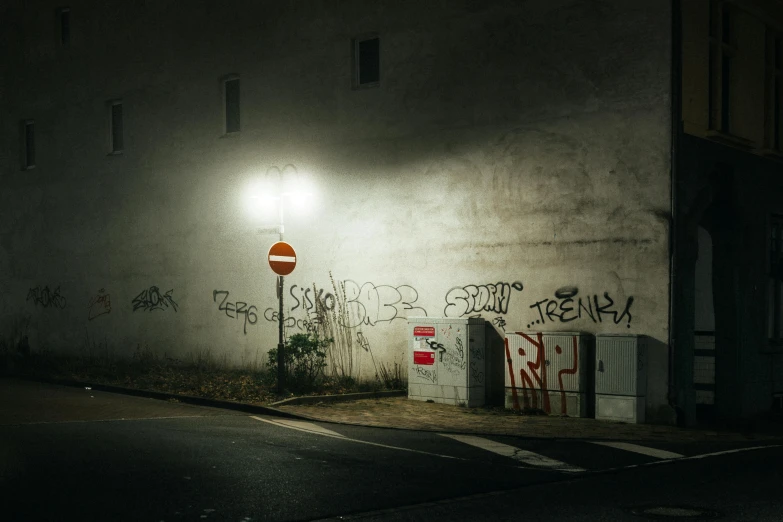 a street light sitting on the side of a building, inspired by Elsa Bleda, pexels contest winner, graffiti, todd hido, a ghetto in germany, concrete walls, christophe szpajdel