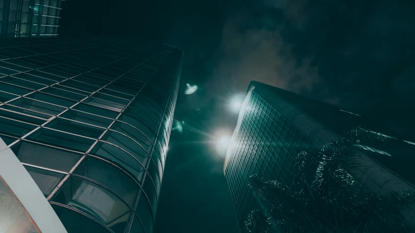a couple of tall buildings next to each other, a picture, pexels contest winner, light and space, moonlight in the darkness, thumbnail, cinematic wide angle, dramatic lighting - n 9
