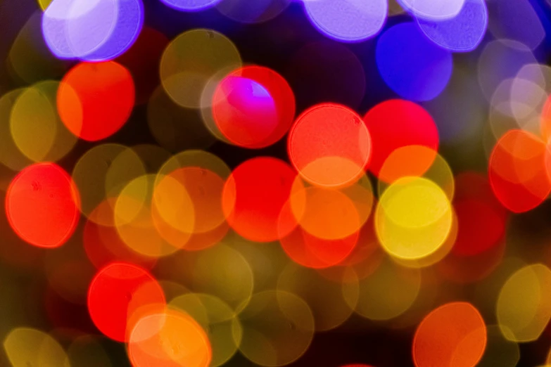 a close up of a christmas tree with many lights, by Jan Rustem, pexels, pointillism, neon circles, red and yellow light, abstract colors, purple and yellow lighting