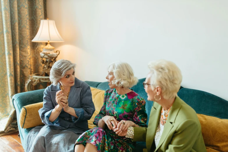 a group of women sitting on top of a couch, a portrait, by Ruth Simpson, unsplash, nursing home, royal family during an argument, threes, blonde women