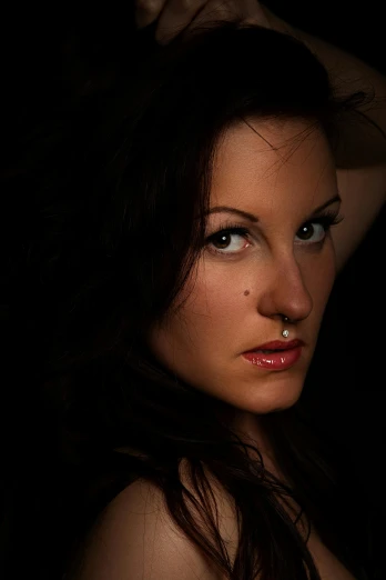 a woman posing for a picture in the dark, a character portrait, inspired by Peter Basch, flickr, seductive tifa lockhart portrait, with anxious piercing eyes, professional studio photograph, taken in the late 2010s