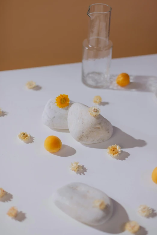 a white table topped with yellow and white flowers, a marble sculpture, by Tan Ting-pho, unsplash, conceptual art, ice cubes, dessert, backscatter orbs, made of cheese