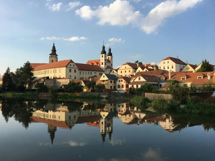 a body of water with buildings in the background, a picture, pexels contest winner, baroque, in legnica, avatar image, small village, profile image