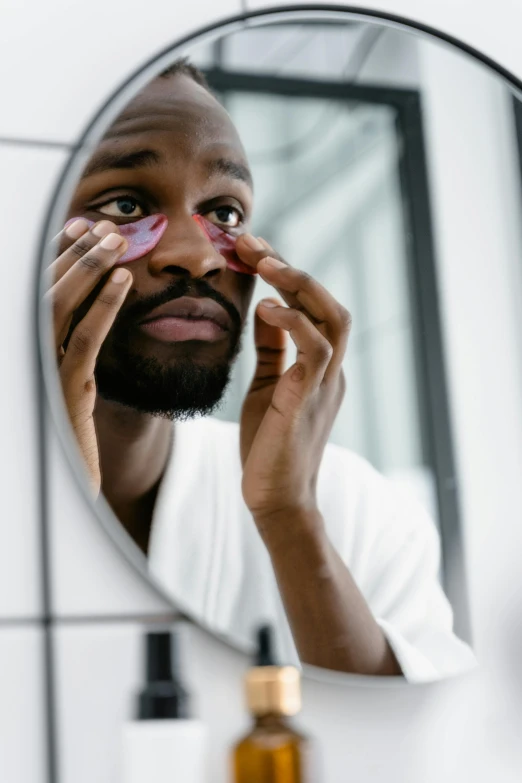 a man shaving his face in front of a mirror, trending on pexels, purple eyes with red eye markers, black man, eye patch over left eye, pink face