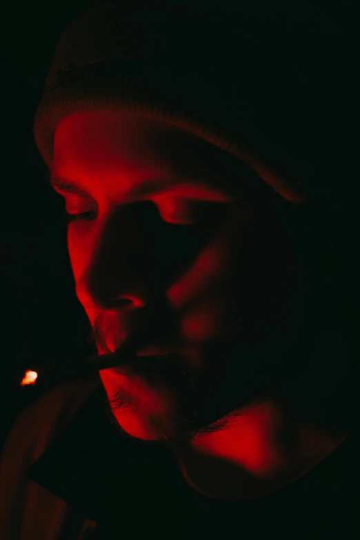 a man smoking a cigarette in the dark, inspired by Elsa Bleda, unsplash, digital art, red cap, pete davidson, low quality photo, eminem