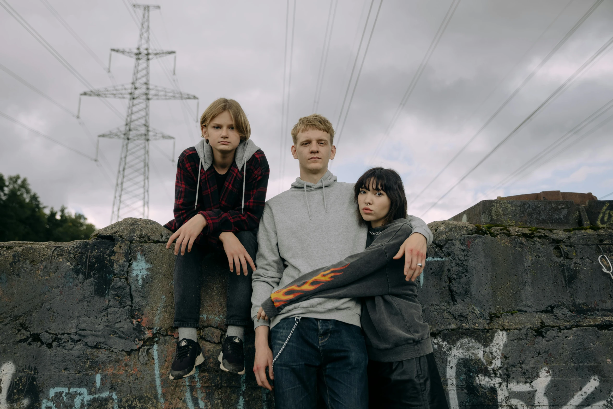 a couple of people that are sitting on a wall, an album cover, unsplash, portrait of family of three, teenage engineering moad, high quality upload, still image from tv series