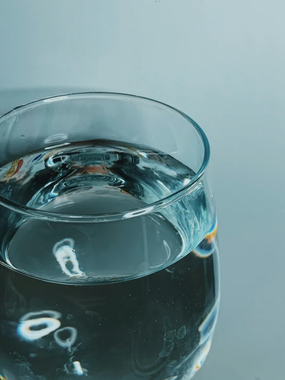 a glass of water sitting on top of a table, by Ryan Pancoast, trending on unsplash, hyperrealism, detail shot, “hyper realistic, high angle close up shot, high quality product photo