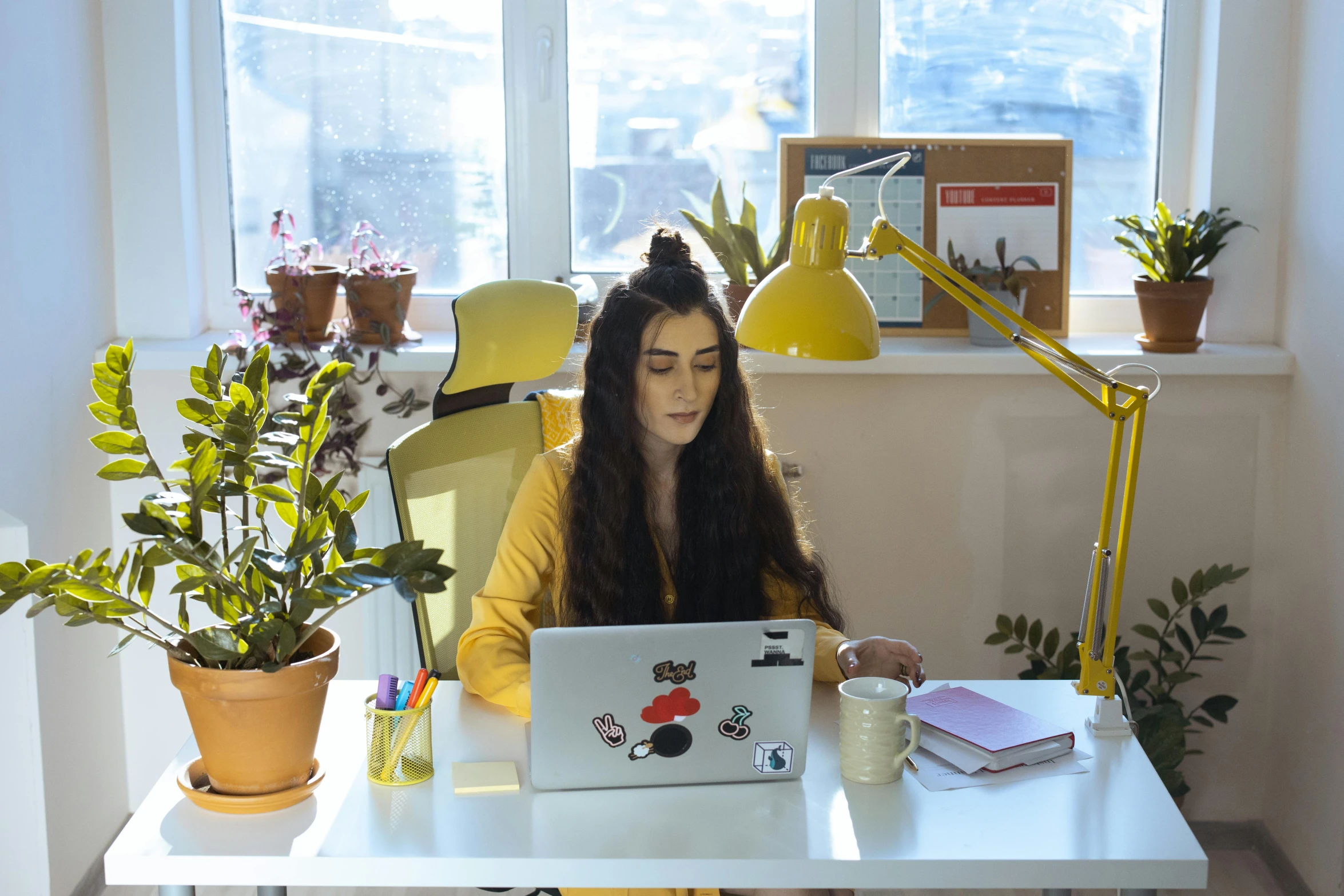 a woman sitting at a desk using a laptop computer, by Julia Pishtar, wearing a yellow hoodie, charli bowater, avatar image