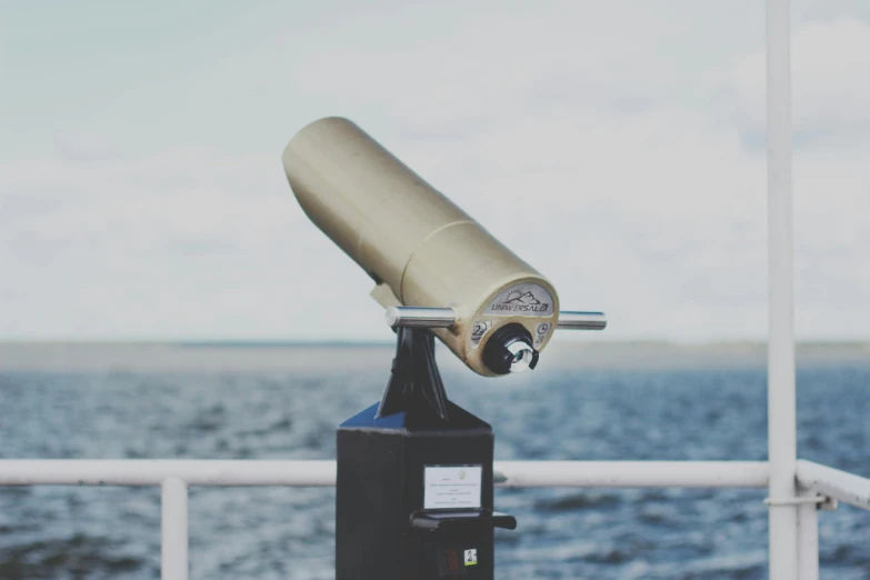 a telescope sitting on top of a boat next to a body of water, by Niko Henrichon, unsplash, miscellaneous objects, portrait photo, instagram post, laser beam ; outdoor