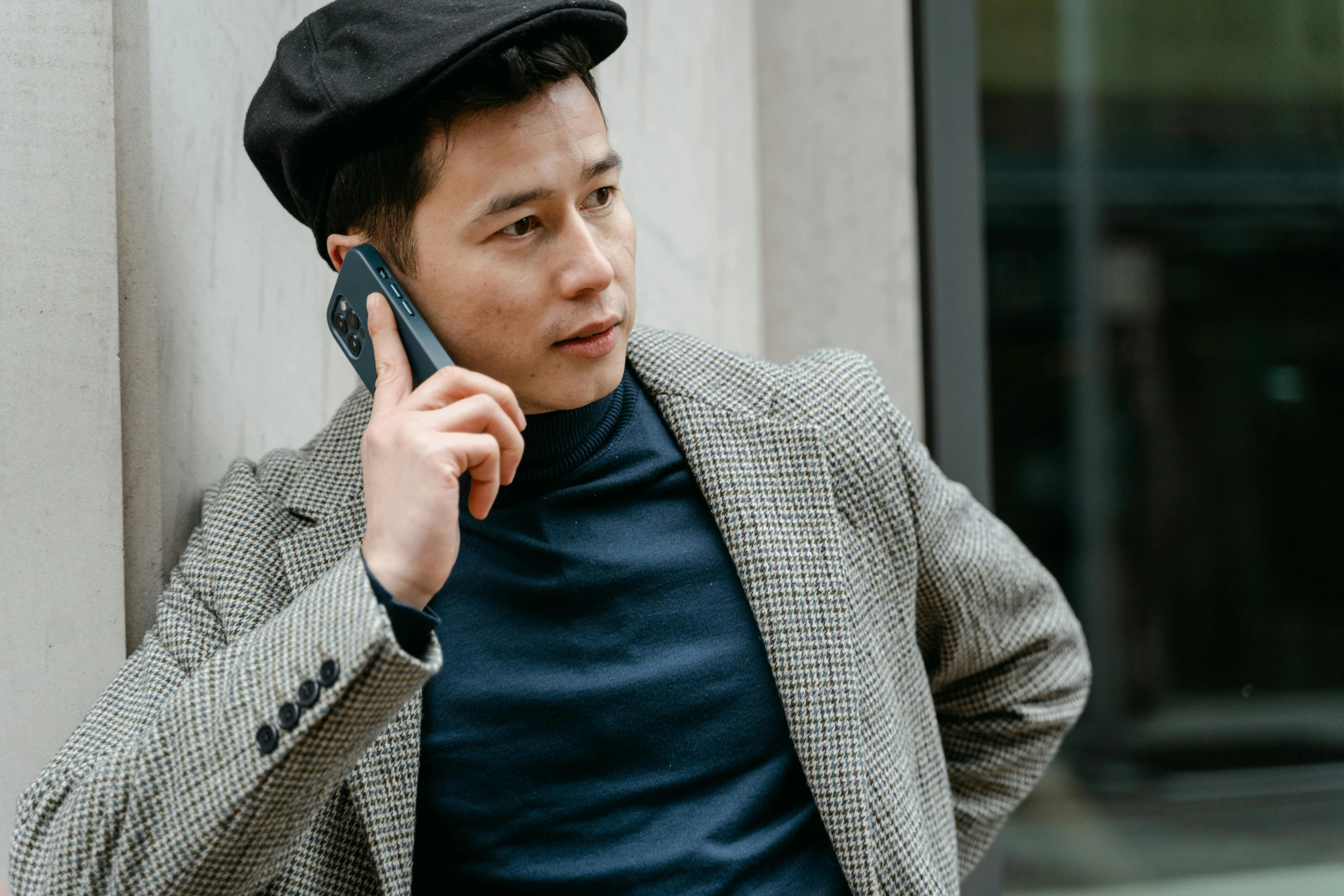 a man talking on a cell phone next to a building, trending on pexels, realism, berets, ethnicity : japanese, wearing elegant casual clothes, thumbnail