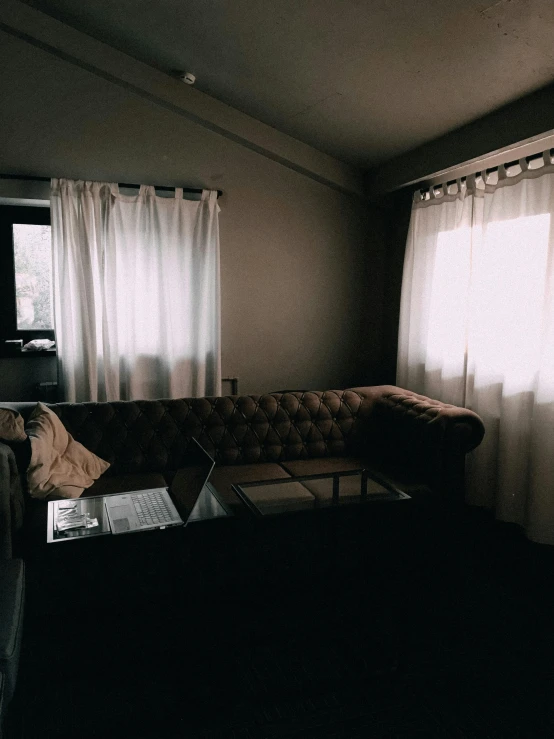 a living room filled with furniture and a window, an album cover, unsplash, dark academia aesthetic, couch desk, vsco, cinematic outfit photo