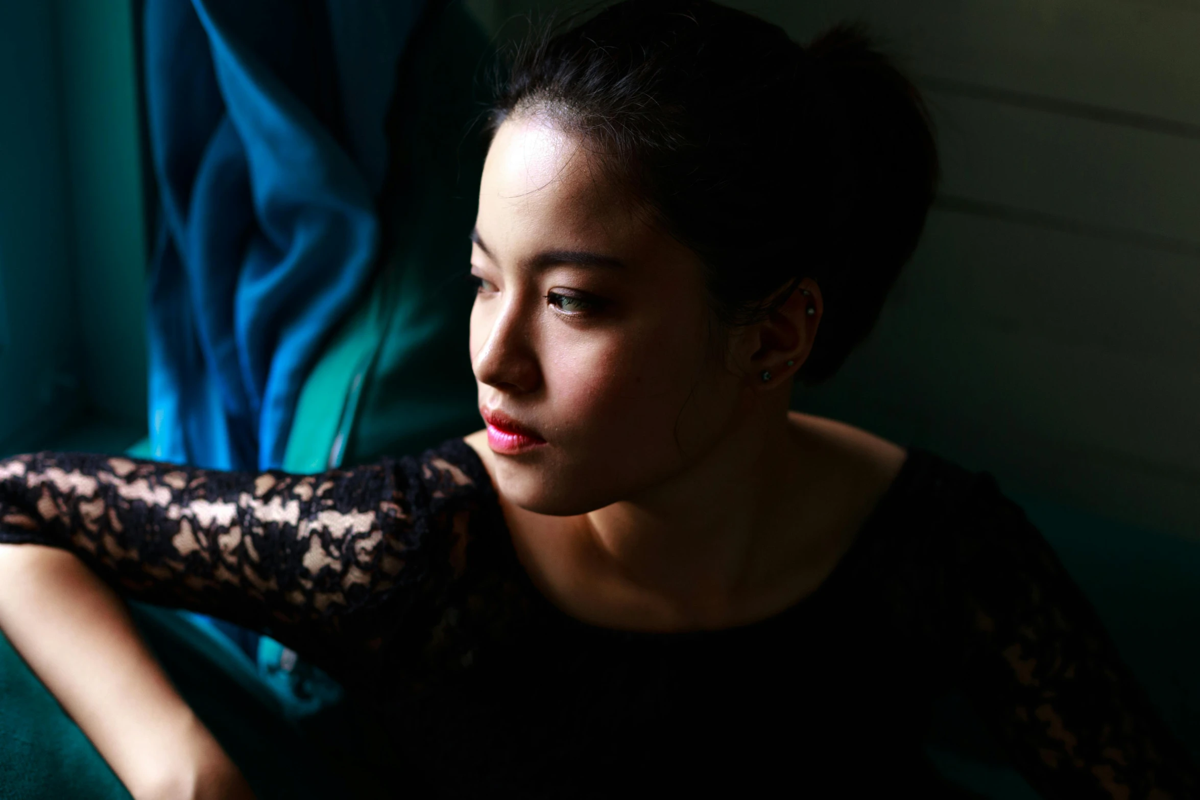 a woman in a black dress sitting on a couch, a portrait, inspired by Xia Shuwen, pexels contest winner, side light, jamie chung, close portrait, young himalayan woman