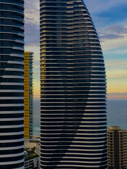 a couple of tall buildings next to each other, by Lisa Milroy, pexels contest winner, curvy build, views to the ocean, spiraling, australia