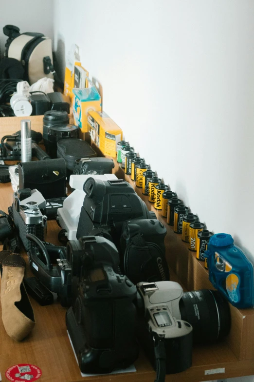 a bunch of cameras sitting on top of a wooden table, inspect in inventory image, back room, shot onfilm, off - white collection