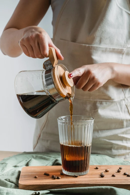 a woman pours coffee into a glass, unsplash, process art, jakarta, instagram post, a wooden, college