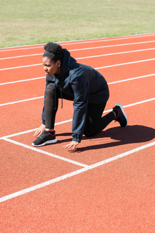 a woman getting ready to run on a track, square, thumbnail, schools, essence