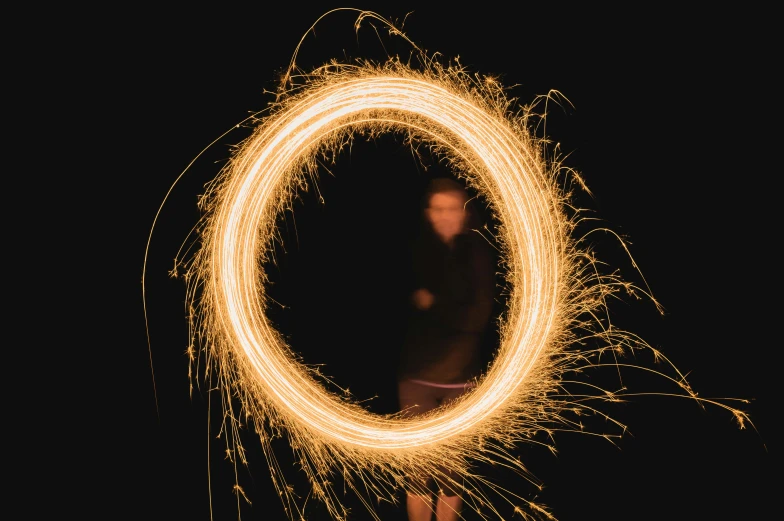 a person holding a sparkler in their hand, an album cover, by Sebastian Spreng, pexels contest winner, art photography, enso, teenage boy, orton effect intricate, orange halo