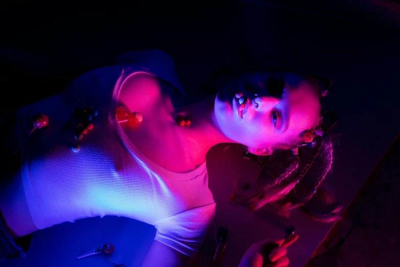 a couple of women laying next to each other, inspired by Elsa Bleda, art photography, blue and red lights, uv blacklight, portrait of kim petras, high fashion photography