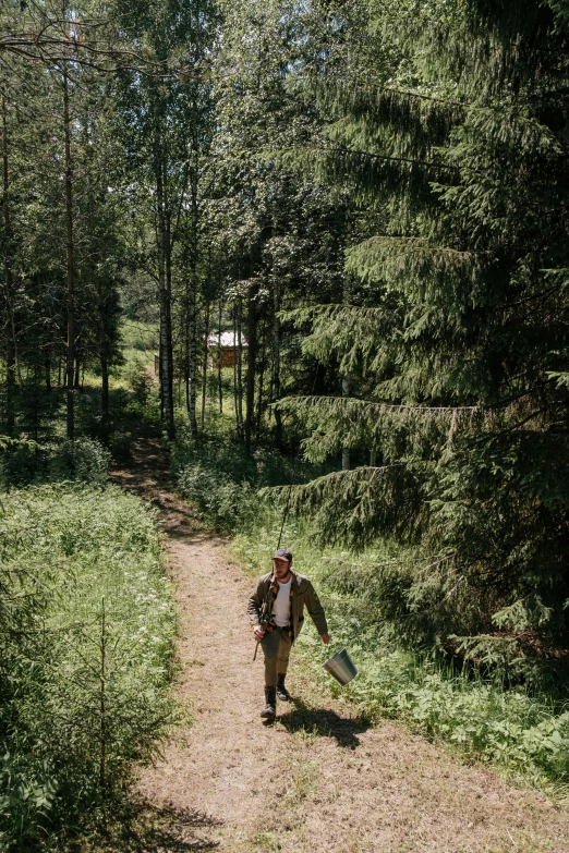 a man walking down a dirt path in the woods, by Julia Pishtar, glamping, russia, exterior, nordic summer